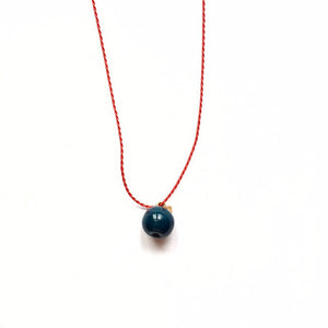 Ceramic dark blue "Apple" pendant on a red string